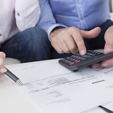 people looking at documents with calculator